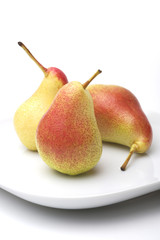 Three pears on a white plate, white background
