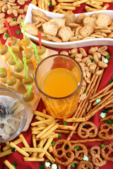 Erfrischungsgetränk mit Salzgebäck im Hintergrund