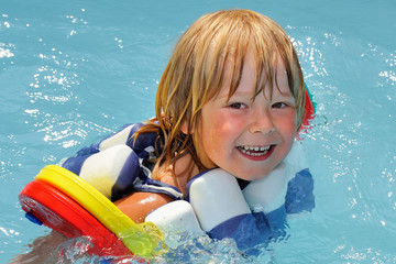 Kind mit Schwimmhilfen im Pool