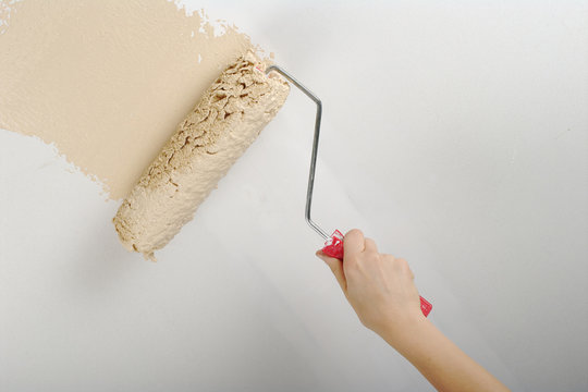 Hand painting with roller on white wall
