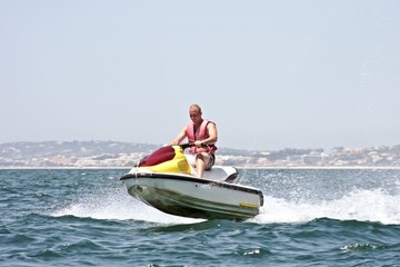 Young guy cruising on the atlantic ocean on a jet ski