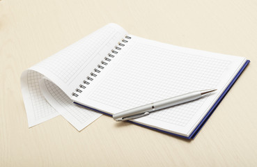 Blank notepad with pen on wood table