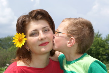 A little boy kisses his mom
