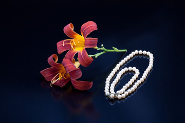 Lilies and a pearl necklace.