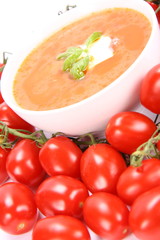Tomato soup decorated with basil and cream with fresh tomatoes
