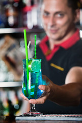 Young bartender with cocktail