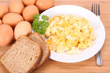 Scrambled eggs,fresh eggs and wholemeal bread, and a fork