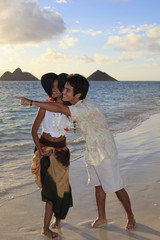 young mixed race couple at the beach in hawaii at sunrise
