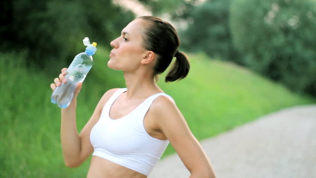 Woman drinking water after sport activities