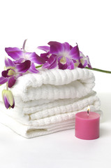 Obraz na płótnie Canvas A beautiful orchid, towel and candles