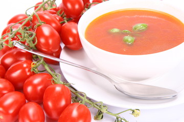 Tomato soup decorated with basil leaves with fresh tomatoes