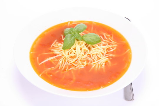 Tomato soup with macaroni and  a spoon
