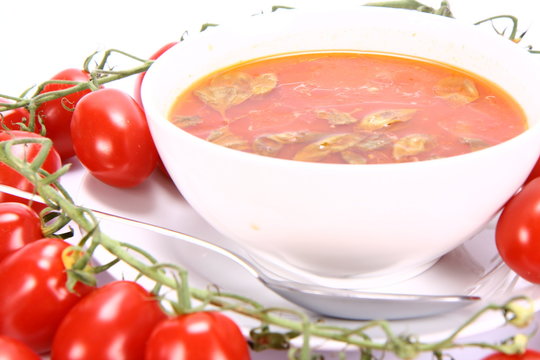 Tomato soup with basil leaves and with fresh tomatoes