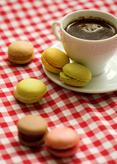 Cup of coffee with traditional French macaroon cookies
