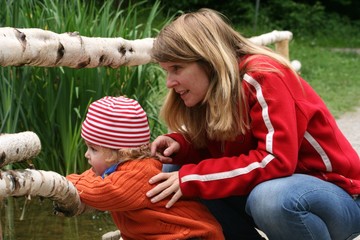 Mutter und Kind beobachten Enten
