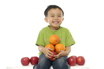 Fototapeta na wymiar three years old boy playing with fruits