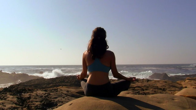 Woman meditating by the ocean - HD