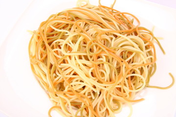 Tricolor cooked spaghetti on a plate in close up