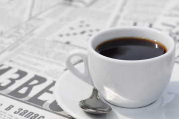 Cup of coffee on Russian newspaper background