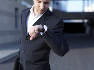 A handsome business man looking at watch