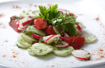 vegetables salad on  white plate. tomatoes and cucumber