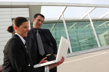 Homme et femme d'affaires devant ordinateur portable