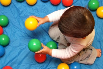 Fototapeta na wymiar Dziecko bawi się z jego piłki
