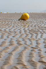 Ondulations sur le sable et bouée