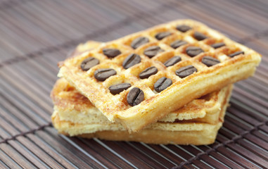 waffles and coffee beans on a bamboo mat