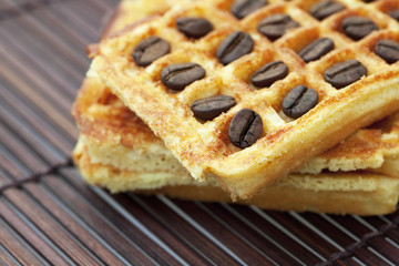 waffles and coffee beans on a bamboo mat