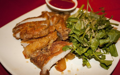 Plate of pork katsu on a white plate with sauce on side