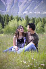 Attractive young couple sitting in the field