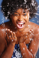 Fototapeta na wymiar Cute African American splashes water to clean her face