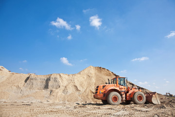 Orange excavator working in a construction environment