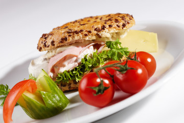 Bagel mit Käseschinkenfüllung und Beilage