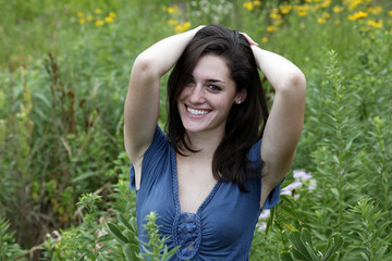 Young woman with arms behind her head