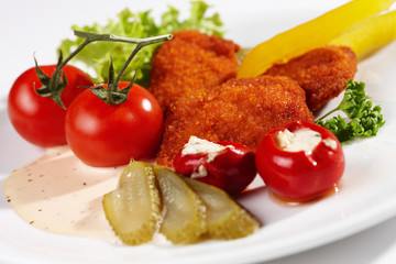 Fototapeta na wymiar Chicken Nuggets mit Tomaten und Salatbeilage