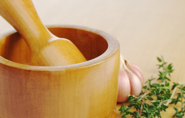 Wooden mortar with garlic and thyme (Selective Focus)