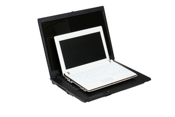 weißes Netbook und schwarzes Laptop im Größenvergleich