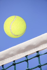 Tennisball fliegt über Tennisnetz