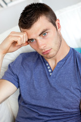 Bored young man sitting on the sofa