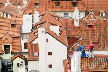 Workers on  Red roofs of Prague seen from Hradcany.