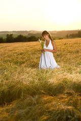 Fototapeta na wymiar Romantic brunette woman in sunset corn field