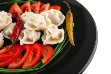 dumplings served with vegetables on black