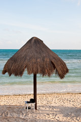 Beach Sandles Under Thatched Umbrella