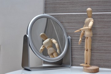 Mannequin bois se regarde dans le miroir