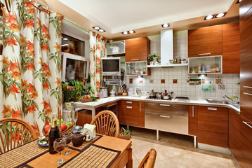 Kitchen interior with wooden furniture, table and many utensils