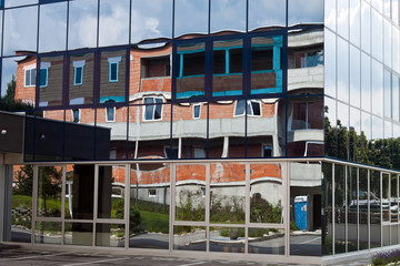 Rohbau eines Wohnhauses spiegelt sich in Fassade