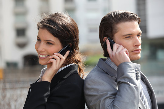 Homme et femme d'affaires au téléphone portable