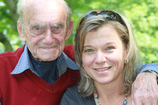 Großvater und Enkelin lachend in grüner Natur - Portrait